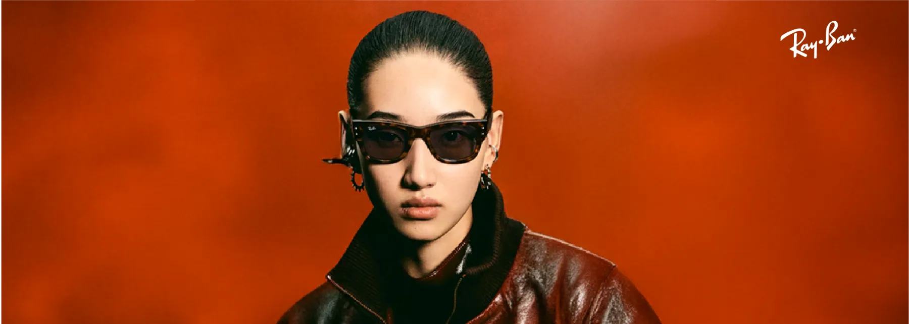 Campaña de Ray-Ban: modelo con gafas de sol de carey sobre fondo rojo