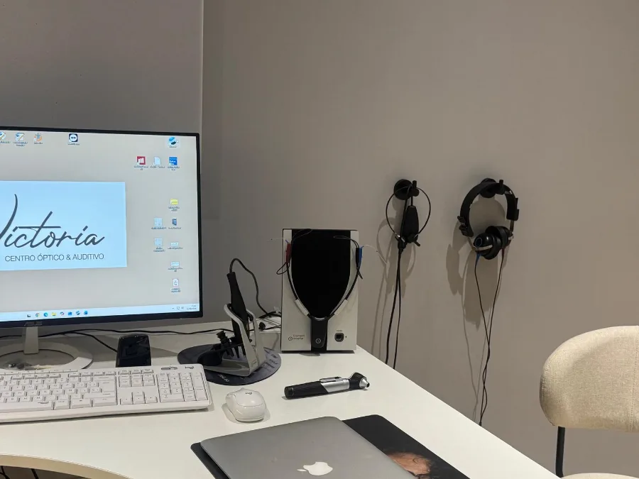 Puesto de trabajo de audiometría: audiómetro, auriculares y pantalla con el logotipo del centro